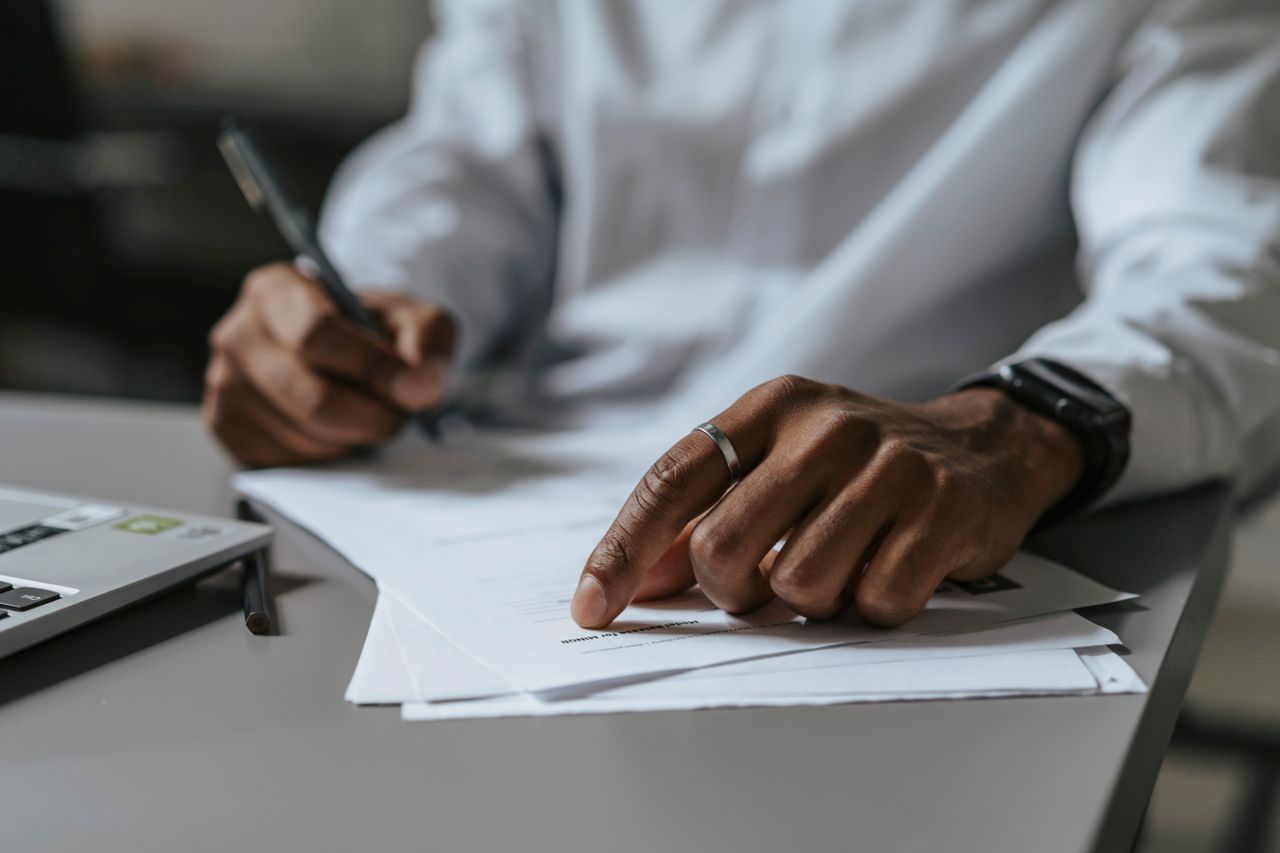 Handwritten edits to documents beside a laptop
