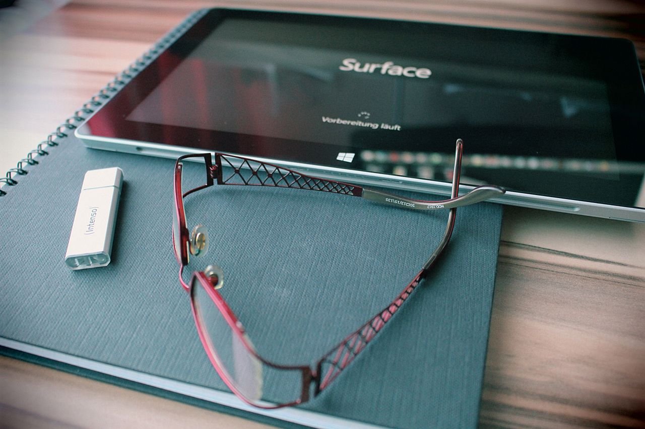 Tablet, glasses and USB drive on a table
