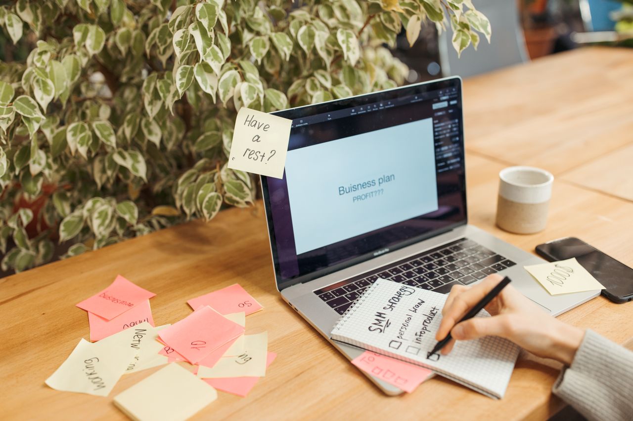 Notebook, sticky notes and laptop on a work surface