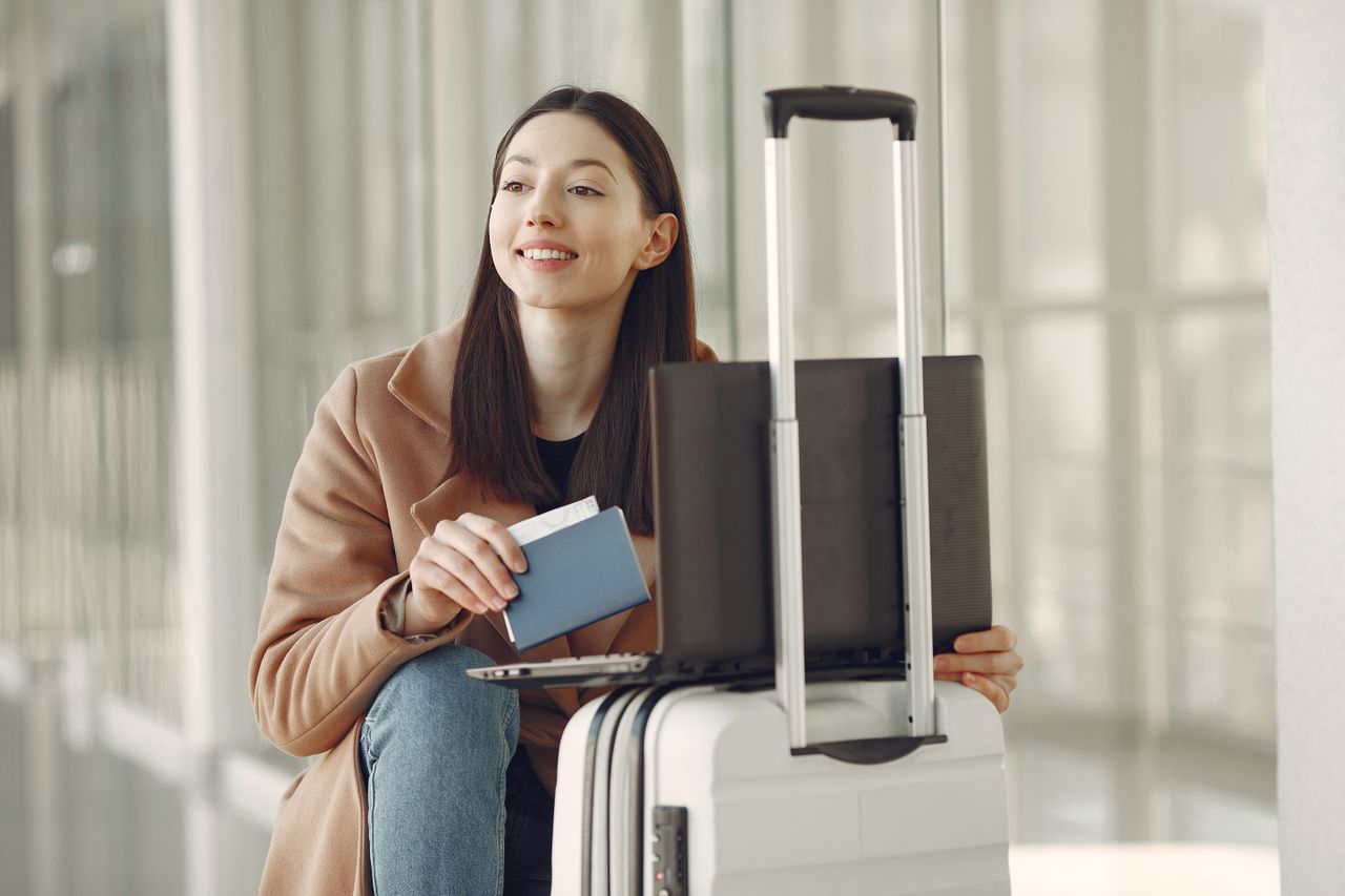 Traveler with passport and laptop at an airport