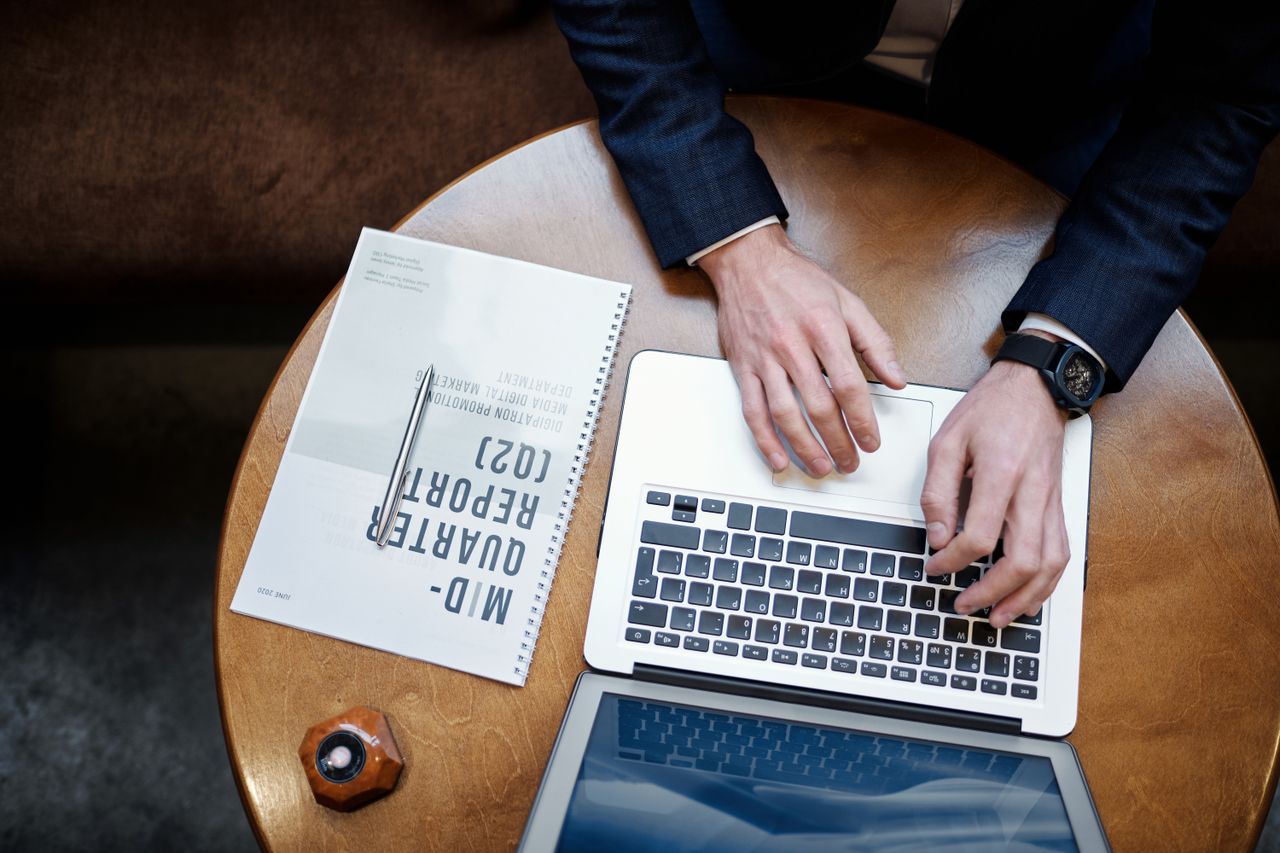 Report and laptop on a wooden table