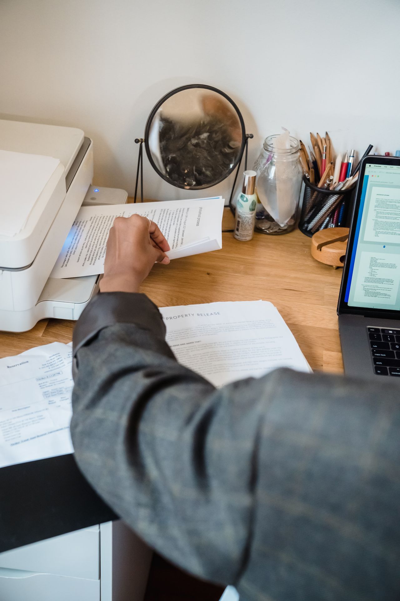 Documents being handled beside a laptop
