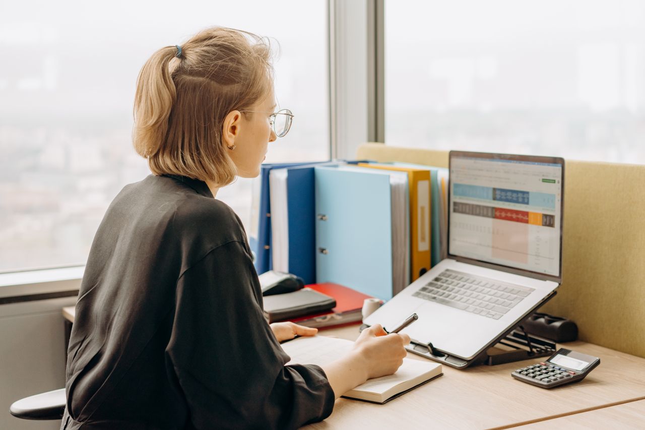A person reviewing spreadsheets on a laptop