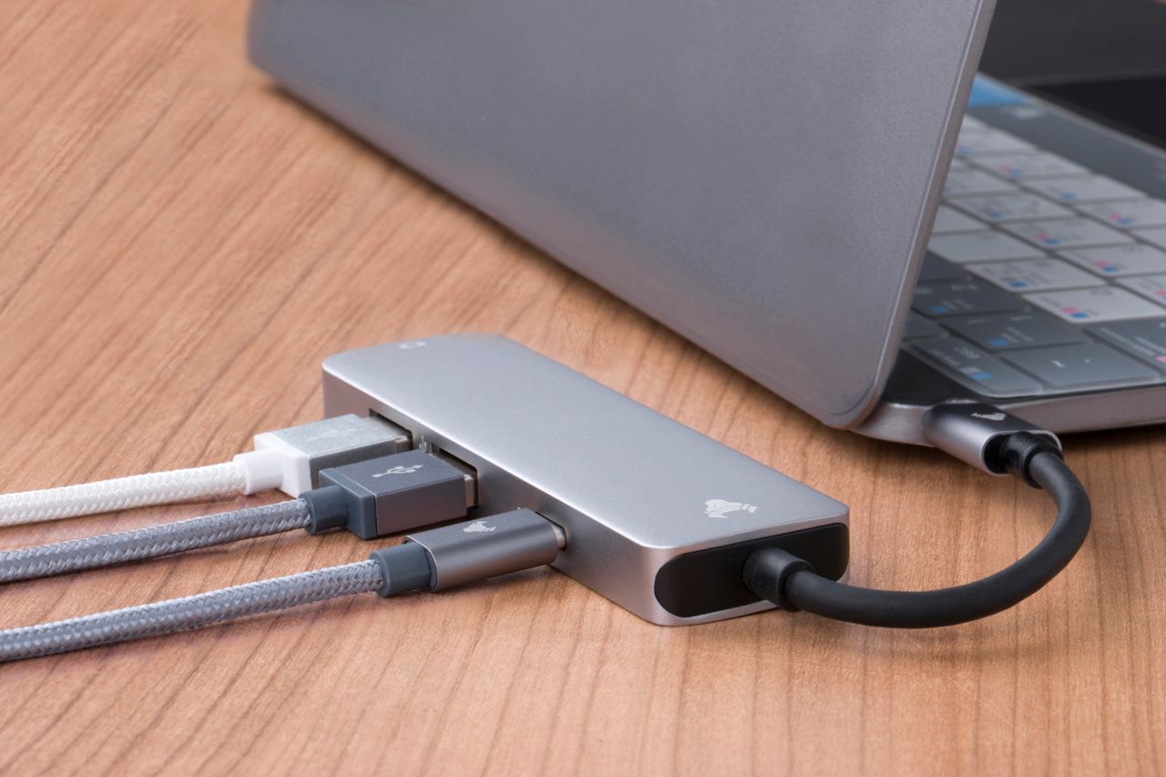 USB hub with connected cables beside a laptop