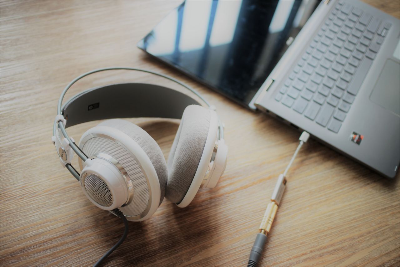 Headphones beside a laptop on a wooden table