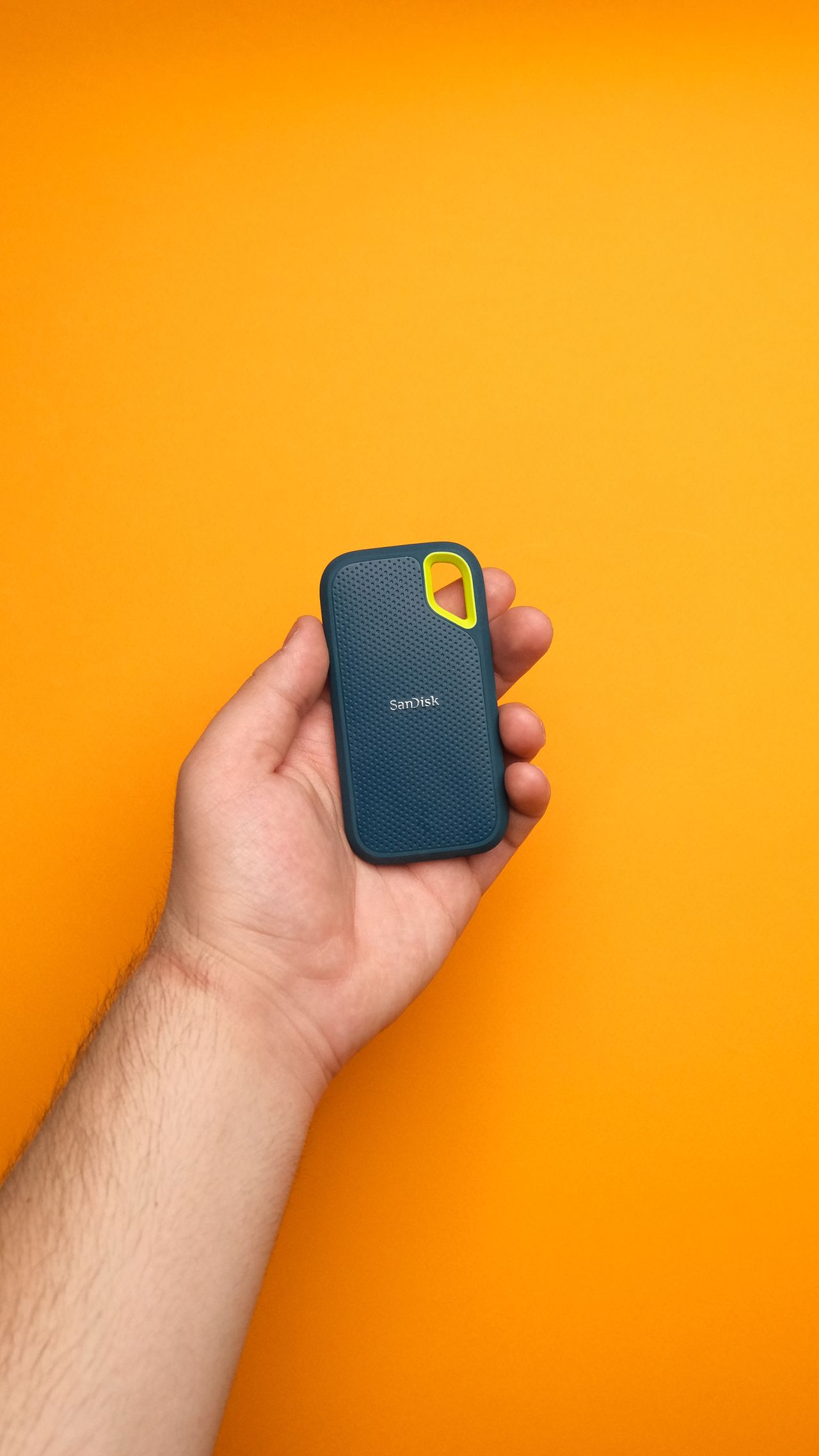 A hand holding a portable SSD