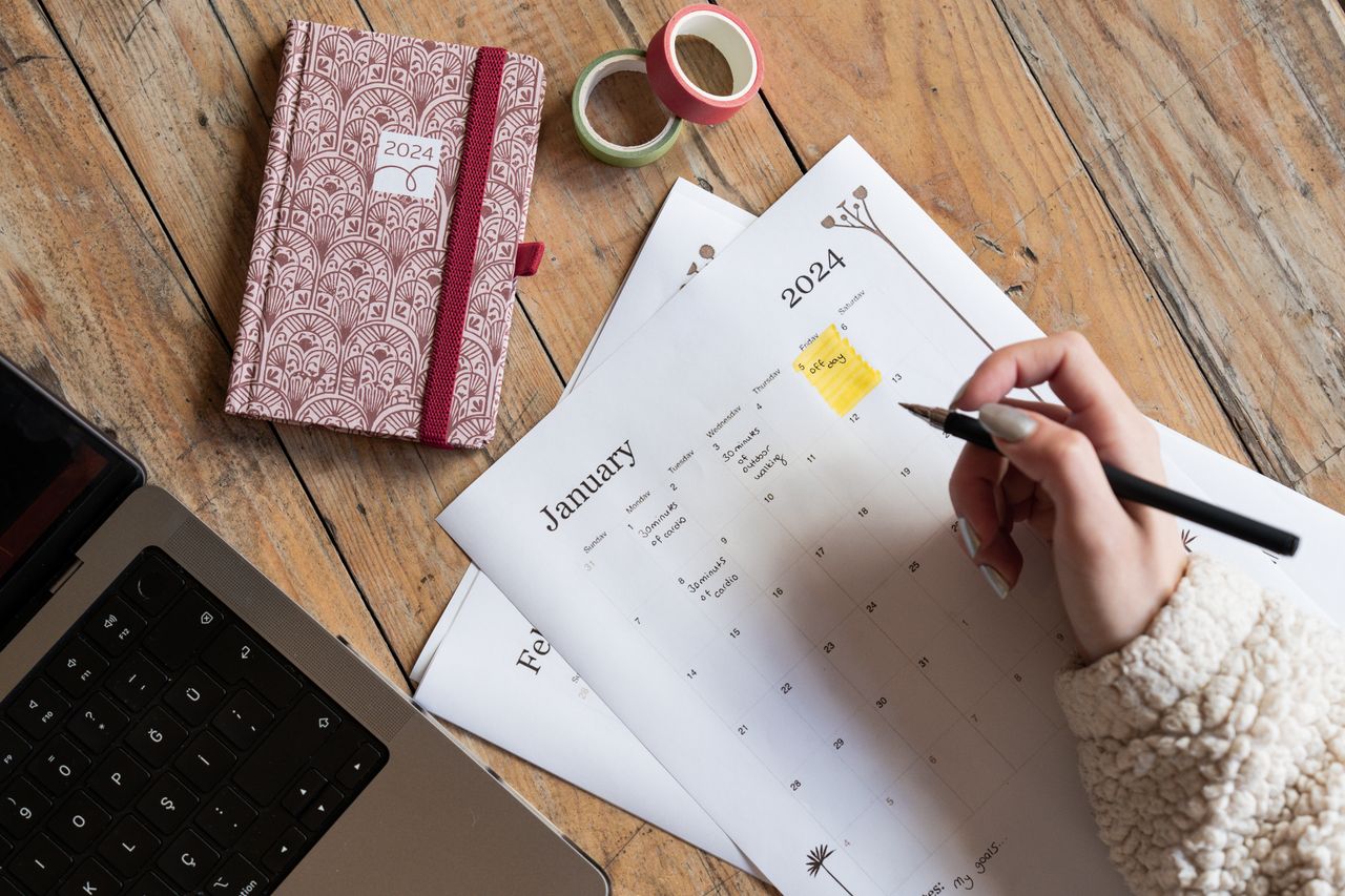 Calendar planning beside a laptop