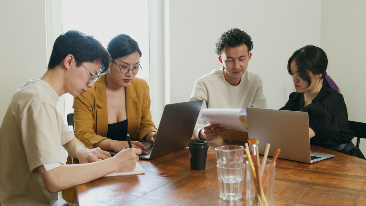 Discussion of documents and laptops in an office