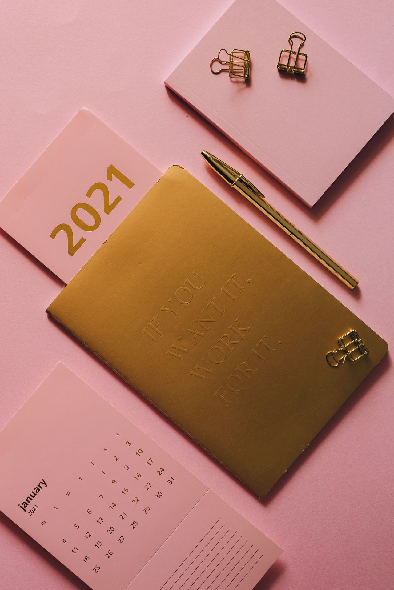 Calendar and notebook on a pink surface